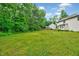 Exterior view of the backyard with a lush lawn and mature trees at 212 Spearhead Pl, Clayton, NC 27520