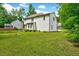 Back exterior of home, featuring a sprawling yard, manicured garden, and deck at 212 Spearhead Pl, Clayton, NC 27520