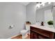 Updated half bathroom with dark wood vanity, toilet, and decorative mirror at 212 Spearhead Pl, Clayton, NC 27520