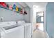 Convenient laundry area featuring a modern washer and dryer, with shelving for storage at 212 Spearhead Pl, Clayton, NC 27520