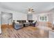 Bright and open living room with a large sectional couch, hardwood floors, and a ceiling fan at 212 Spearhead Pl, Clayton, NC 27520