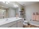 Bathroom featuring a double vanity with framed mirror, decorative shelves, and tiled shower at 215 Outwater Ridge Dr, Garner, NC 27529
