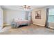 Cozy bedroom with plush carpeting, ceiling fan, and windows, creating a relaxing and comfortable atmosphere at 215 Outwater Ridge Dr, Garner, NC 27529