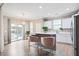 Bright kitchen boasts white cabinets, stainless appliances, breakfast bar, and sliding doors to outdoor living space at 215 Outwater Ridge Dr, Garner, NC 27529