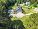 An aerial view of a charming two-story home with a large yard, swimming pool, and multiple garages at 227 Paraggi Ct, Clayton, NC 27527