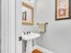 Charming half bathroom with pedestal sink, decorative mirror, and elegant wall decor at 227 Paraggi Ct, Clayton, NC 27527