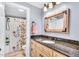 Bathroom with a vanity, granite countertop, framed mirror, and a shower featuring a floral curtain at 227 Paraggi Ct, Clayton, NC 27527