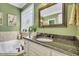 Bathroom boasts garden tub, granite countertops, and a decorative stained-glass window at 227 Paraggi Ct, Clayton, NC 27527