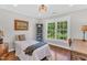 Bright bedroom featuring hardwood floors, a large window, and simple decor, creating a cozy and inviting space at 227 Paraggi Ct, Clayton, NC 27527