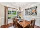A wood dining table with seating for six situated next to a window with a view of the yard at 227 Paraggi Ct, Clayton, NC 27527