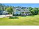 Charming two-story blue house with a three-car garage, manicured lawn, and mature trees at 227 Paraggi Ct, Clayton, NC 27527