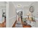 Entryway with hardwood floors, neutral colored walls, lamp, plant, console table and view into other rooms at 227 Paraggi Ct, Clayton, NC 27527