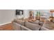 Well-lit living room with sectional sofa, hardwood floors, and a game table, perfect for relaxing and entertaining at 227 Paraggi Ct, Clayton, NC 27527