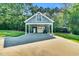 Exterior shot of a blue outbuilding with a carport and a manicured lawn at 227 Paraggi Ct, Clayton, NC 27527