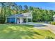 Exterior shot of a blue outbuilding with a carport and a manicured lawn at 227 Paraggi Ct, Clayton, NC 27527
