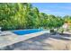 Inviting backyard pool with ample lounge space for relaxing by the water surrounded by lush green trees at 227 Paraggi Ct, Clayton, NC 27527