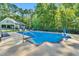 Beautiful backyard pool with fence, lounge chairs, pool house and basketball hoop, perfect for relaxation and entertainment at 227 Paraggi Ct, Clayton, NC 27527