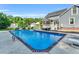 Backyard pool with lounging chairs and lush landscaping adjacent to patio and screened in back porch at 227 Paraggi Ct, Clayton, NC 27527