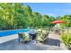 Outdoor lounge area and pool with sunbeds surrounded by mature trees at 227 Paraggi Ct, Clayton, NC 27527
