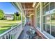 Covered porch with brick flooring, a table set and hanging flower basket and rocking chairs at 227 Paraggi Ct, Clayton, NC 27527