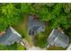 Aerial view of a home's roof fitted with solar panels and nestled among lush trees at 2305 Bryarton Woods Dr, Raleigh, NC 27606