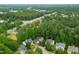 Aerial view showcases the home among a verdant neighborhood with mature trees and nearby roadways at 2305 Bryarton Woods Dr, Raleigh, NC 27606