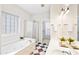 Bright bathroom featuring shower, jacuzzi, tiled floor, double sink, and decorative plants at 2305 Bryarton Woods Dr, Raleigh, NC 27606