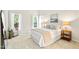 Bright bedroom featuring white linens, decorative pillows, bedside tables and lamps, chair, and large windows at 2305 Bryarton Woods Dr, Raleigh, NC 27606
