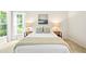 A well lit bedroom showcasing white linens, decorative pillows, bedside tables with lamps, and large windows at 2305 Bryarton Woods Dr, Raleigh, NC 27606
