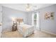 Cozy bedroom with light gray walls, a ceiling fan, and a window dressed with white curtains at 2305 Bryarton Woods Dr, Raleigh, NC 27606