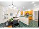 Open kitchen with stainless appliances, oak cabinets, green countertop bar, and tile floors open to living area at 2305 Bryarton Woods Dr, Raleigh, NC 27606