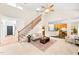Inviting living room featuring a staircase, high ceiling, ceiling fan, and an open view to the kitchen at 2305 Bryarton Woods Dr, Raleigh, NC 27606
