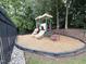 Community playground in a fenced area, featuring slides, climbing structures, and wood chip ground cover at 2305 Bryarton Woods Dr, Raleigh, NC 27606