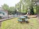Community playground and picnic tables, with mature trees near a fenced in pool, provide a relaxing outdoor space at 2305 Bryarton Woods Dr, Raleigh, NC 27606