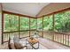Inviting screened porch with comfortable seating, wood floors, and scenic views of surrounding greenery at 2305 Bryarton Woods Dr, Raleigh, NC 27606