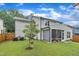 Backyard view with a screened-in porch, green lawn, and mature trees at 2721 Jazzy St, New Hill, NC 27562
