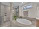 Modern bathroom with a tiled shower and a standalone bathtub with a view at 2721 Jazzy St, New Hill, NC 27562