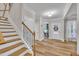 Bright foyer with hardwood floors, staircase, and an office with natural light at 2721 Jazzy St, New Hill, NC 27562