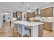 Kitchen boasts a large center island, pendant lighting, stainless appliances, and ample counter space at 2721 Jazzy St, New Hill, NC 27562