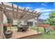 Outdoor patio area with a wooden pergola, dining set, and comfortable seating at 2721 Jazzy St, New Hill, NC 27562