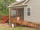 View of the house's screened-in porch with pet ramp access and wooden deck with stairs at 30 Cole Creek Way, Franklinton, NC 27525