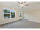 Spacious bedroom with neutral carpet, ceiling fan, and bright windows at 304 Ford Meadows Dr, Garner, NC 27529