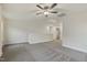 Expansive carpeted bonus room with ceiling fan, attic access and view of the upstairs landing at 304 Ford Meadows Dr, Garner, NC 27529