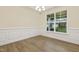 Sun-drenched dining space with hardwood floors, traditional wainscoting, and a view to the backyard at 304 Ford Meadows Dr, Garner, NC 27529
