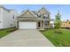 Inviting two-story home with a brick and siding facade, two-car garage, and freshly landscaped front yard at 304 Ford Meadows Dr, Garner, NC 27529