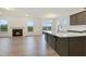 Open-concept kitchen with a large island, stainless appliances, and a cozy fireplace at 304 Ford Meadows Dr, Garner, NC 27529