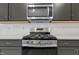Stainless steel oven and microwave appliances, white backsplash and gray cabinets offer modern kitchen design at 304 Ford Meadows Dr, Garner, NC 27529