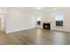 This living room is bathed in natural light and features wood-grain flooring and a cozy fireplace at 304 Ford Meadows Dr, Garner, NC 27529