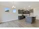 The open kitchen design is complemented by gray cabinets, stainless steel appliances and wood grain flooring at 304 Ford Meadows Dr, Garner, NC 27529