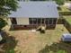 Aerial view of a home's backyard featuring a screened porch, lawn, and mature trees at 304 S Smith St, Clayton, NC 27520